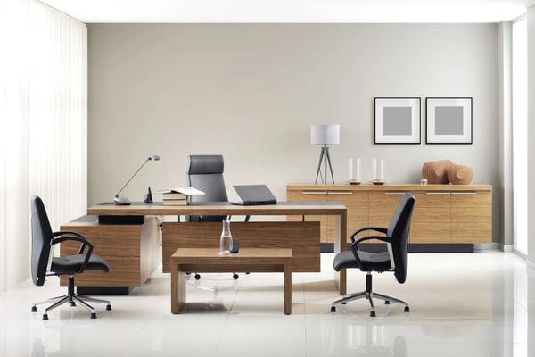 Modern office with wooden desks, black office chairs, tripod lamp, and framed wall art in neutral tones